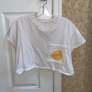 Slightly cropped white loose tee with yellow “good vibes”